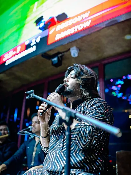 A side profile of our singer, lost in the melody. This photo highlights the focus and concentration that goes into delivering a flawless vocal performance.