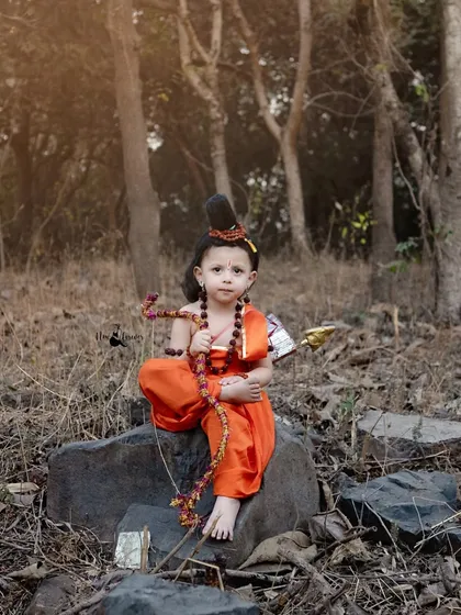 Seated on a rock in the woods, our little Ram looks out with a thoughtful expression. This outdoor session adds a layer of authenticity and natural beauty to the theme.