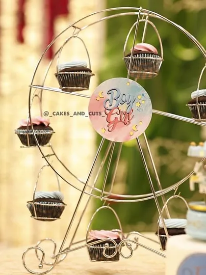 A cupcake ferris wheel is a fun and unique way to display treats at a baby shower.