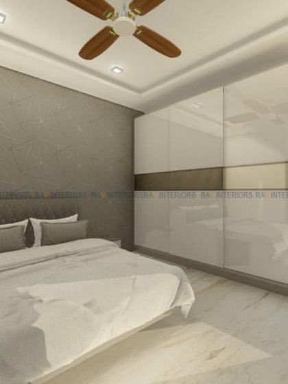 A minimalist bedroom with a grey textured accent wall and a high-gloss white sliding wardrobe.