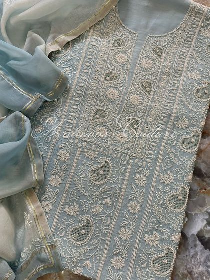 A flat-lay of the suit on a marble background, emphasizing its luxurious quality.