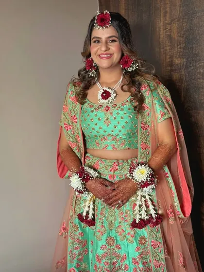 The full Haldi look, showcasing the beautiful floral jewelry and a makeup style that is both festive and natural.