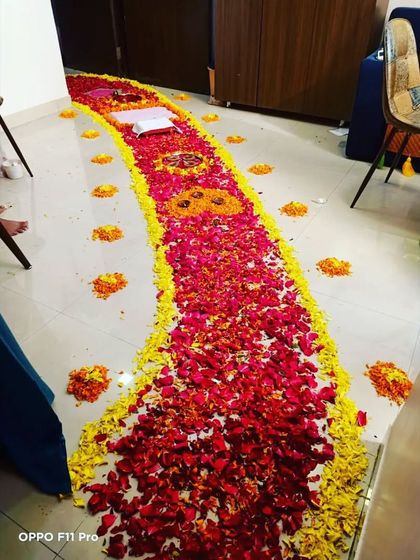 A traditional 'griha pravesh' or welcome home decoration for a newborn baby girl, featuring a long carpet of flower petals.