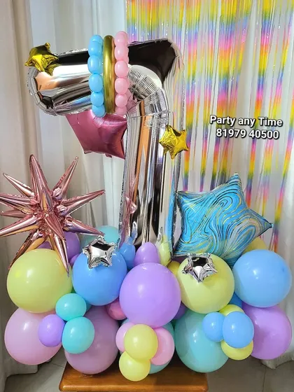 A custom balloon bouquet for a 7th birthday. It features a large number '7' foil balloon surrounded by a mix of pastel and star-shaped foil balloons.