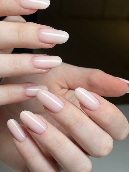 A sheer, milky nude polish on long, oval-shaped nails. This look is the epitome of elegance and sophistication.