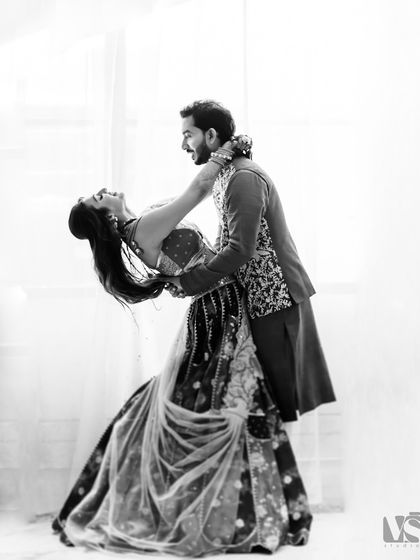 A classic black and white dance pose from a couple's shoot. Her joyful lean back and his supportive hold create a dynamic and timeless image of trust and happiness.