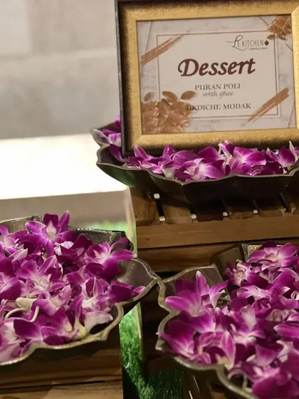 Our dessert station featuring traditional Maharashtrian sweets like Puran Poli with ghee and Ukadiche Modak, beautifully presented with fresh orchids.