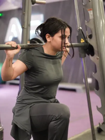 A member demonstrates excellent form and focus while doing lunges using the Smith machine, ensuring a safe and effective leg workout.
