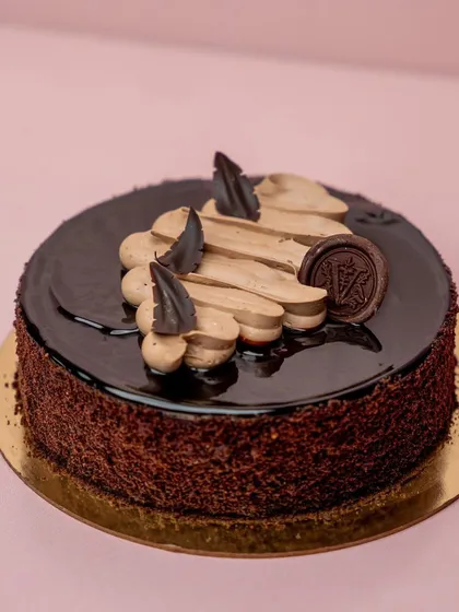 Four years on, and our Ultimate Belgian Chocolate cake is still one of our bestsellers. This cake features rich, decadent chocolate layers, a glossy ganache topping, and piped chocolate cream.