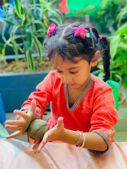 A young artist fully absorbed in her craft. The greenery in our studio provides a beautiful, natural backdrop for our creative sessions.