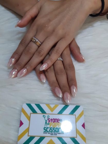 This is the popular 'glazed donut' or pearl chrome look. I applied a special powder over a neutral base to give these almond-shaped nails a beautiful, iridescent sheen.