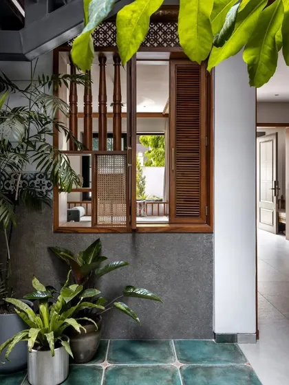A beautifully detailed wooden window looks out from an interior room into the central courtyard, enhancing the home's internal connectivity.
