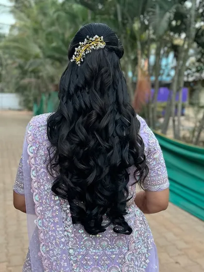 Soft, cascading curls are a perfect choice for a modern reception hairstyle. We added a delicate, sparkling hair accessory to complete this romantic look, which pairs beautifully with both lehengas and reception sarees.