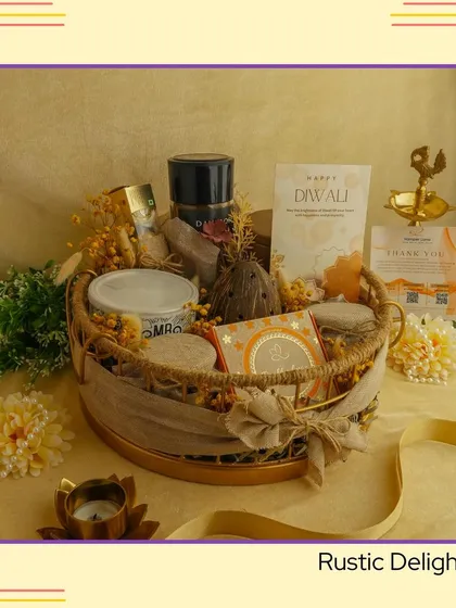 The 'Rustic Delight' hamper. A charming, earthy basket filled with a mix of modern and traditional items, including snacks, a diya, and other decorative pieces.