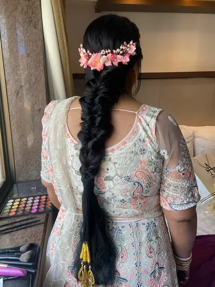 A close-up of the stunning fishtail braid with a pink floral crown. The detail in both the braid and the accessory is exquisite.