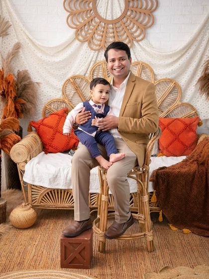 A classic father and son portrait. The warm, earthy tones of the boho setup add a cozy and inviting feel to this timeless shot.