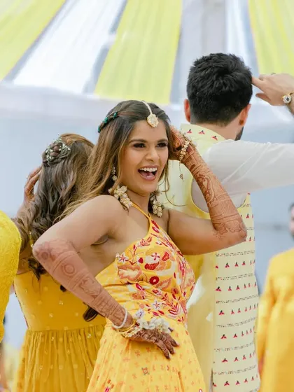 The bride dancing with joy at her Haldi ceremony. We create an atmosphere where everyone feels free to celebrate.