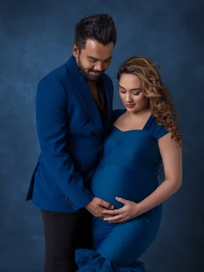 Both parents gently holding the bump, a simple and powerful image of their shared love for their baby.
