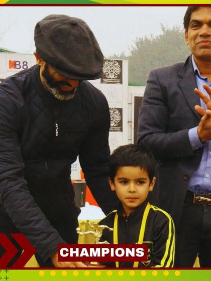 A young champion receives his trophy. We celebrate every achievement, big or small, to build confidence.