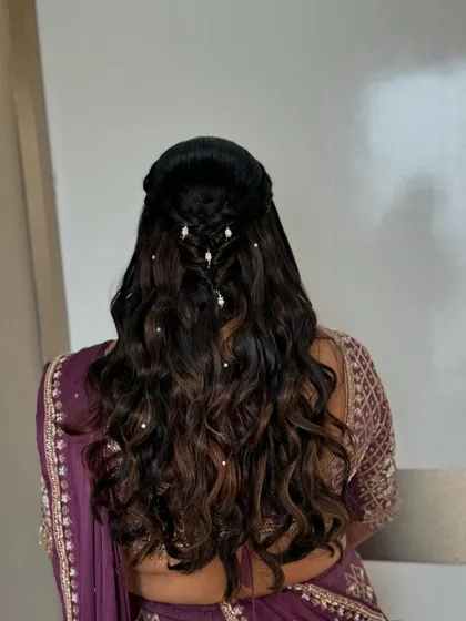 A simple yet elegant hairstyle for the sister of the bride, featuring soft braids and pearl accessories.