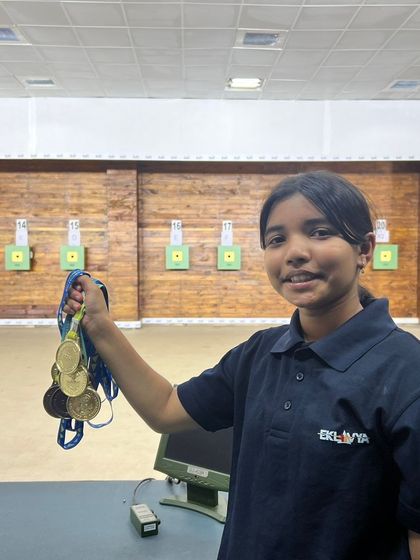 One of our young champions displaying her impressive collection of medals won at a state-level competition, right here on our shooting range.