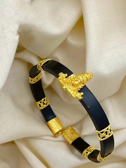 This 92.5 silver gold-plated men's kada features a Shankha (conch) motif. The black band contrasts beautifully with the intricate gold-plated details, making it a unique spiritual accessory.