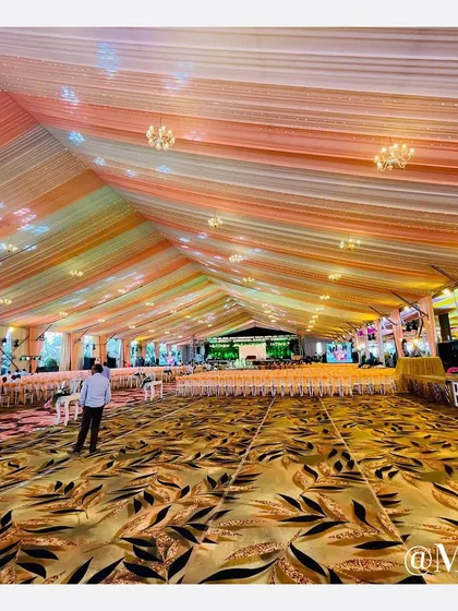 The interior of the massive German hanger tent used for 'The Bhosale Wedding'. We draped the entire ceiling in pastel fabrics and installed elegant chandeliers to transform the industrial structure into a luxurious hall.