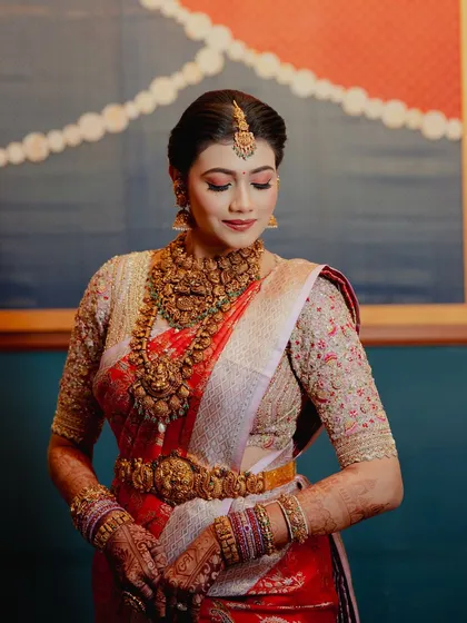 An elegant portrait of the bride, her traditional attire and jewelry perfectly enhanced by the intricate henna on her hands.