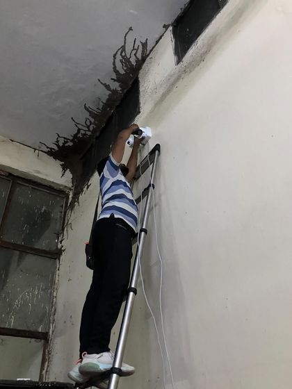Installing a camera on a rough, unfinished wall in a factory. Our job is to secure your property, regardless of the site conditions.