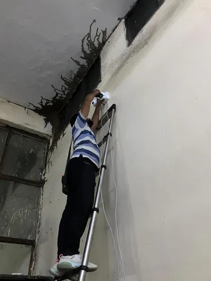 Installing a camera on a rough, unfinished wall in a factory. Our job is to secure your property, regardless of the site conditions.