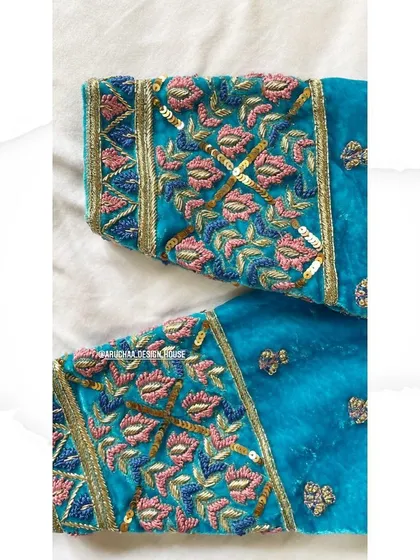 A detailed close-up of the sleeve embroidery on the velvet blouse, showing the mix of threadwork and sequins.