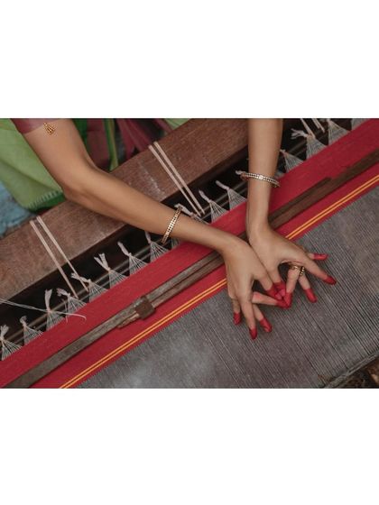 The hands of a dancer meet the threads of a loom. A detail shot from the Jamakalam revival project, highlighting the connection between two intricate art forms.