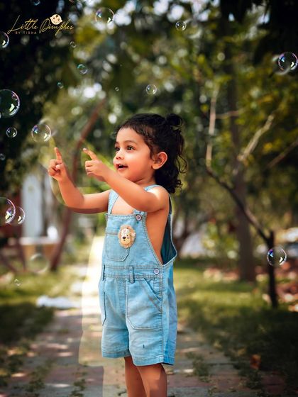 Another shot from the bubble session, capturing her pointing at the magic floating by.