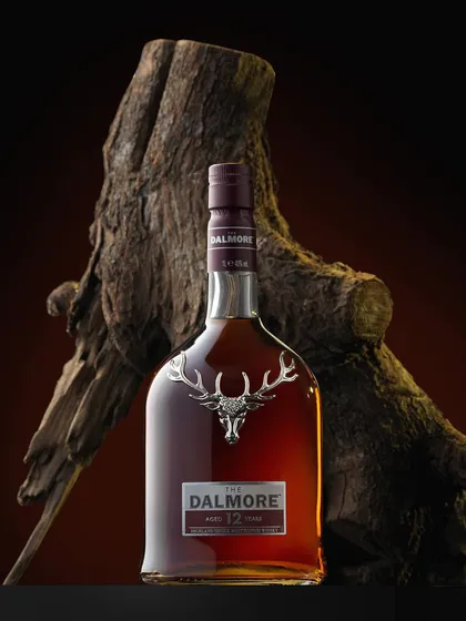 This moody shot of The Dalmore 12 was inspired by the weather on the day of the shoot. The gnarled wood provides a rugged, natural backdrop that contrasts beautifully with the bottle's elegant design and the iconic silver stag.