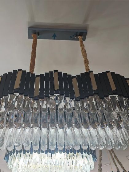 A modern chandelier with a mix of black and crystal elements. This fixture is perfect for adding a touch of drama and sophistication to a dining room.