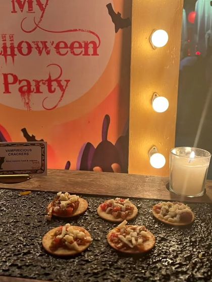 'Vampiricious Crackers' displayed in front of a 'My Halloween Party' light-up sign. The presentation on a dark, textured slate adds to the spooky aesthetic.