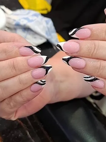 An abstract zebra-inspired French tip. This design combines the classic French base with a bold black and white pattern for a wild and trendy look.