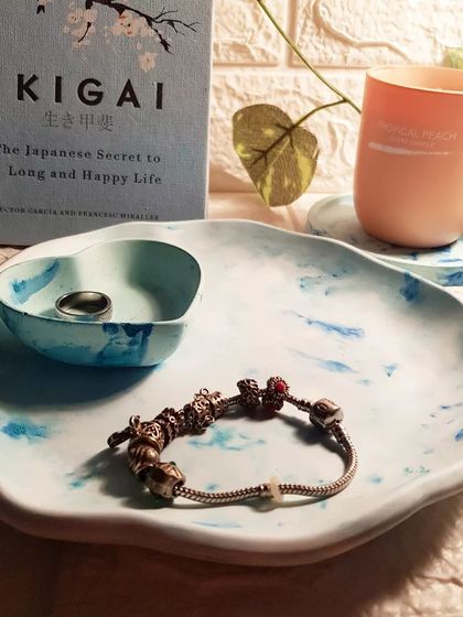 A closer look at the blue marble concrete set, styled with a bracelet and ring. The imperfections and air bubbles are part of concrete's unique charm.