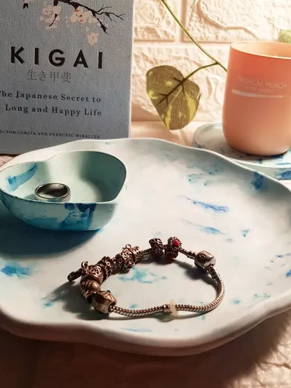 A closer look at the blue marble concrete set, styled with a bracelet and ring. The imperfections and air bubbles are part of concrete's unique charm.