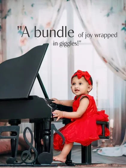 A bundle of joy wrapped in giggles. This little girl in her red dress is the star of the show in our piano-themed studio session.