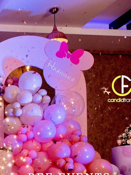 A magical moment at the Minnie Mouse party, with confetti raining down over the beautiful balloon decor. The pink and gold color scheme creates a glamorous and fun atmosphere.