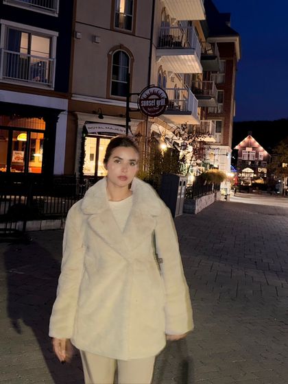 A full-body shot walking down the street in Blue Mountain Village at night.