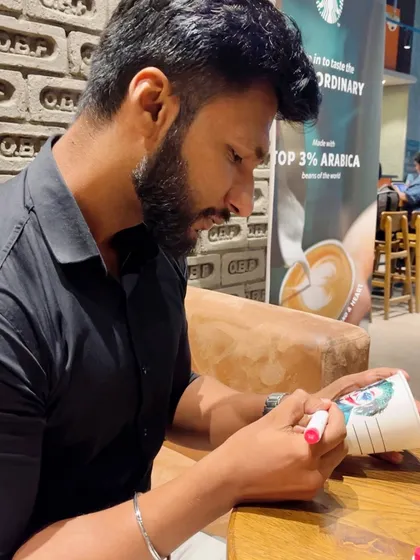 Here I am, focused on creating the coffee cup art at a Starbucks. Inspiration can strike anywhere, and any surface can become a canvas.