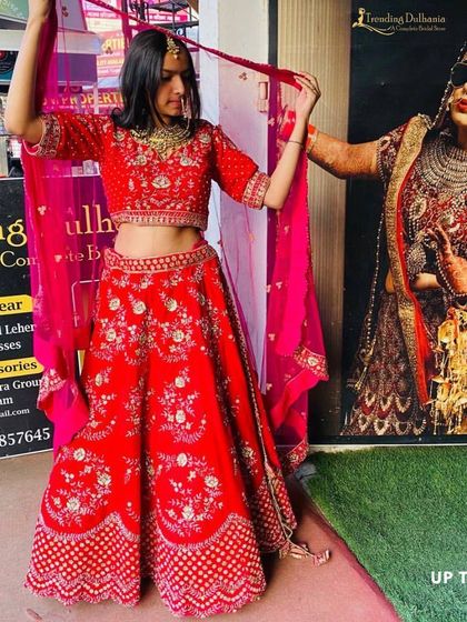 Trying on a classic red bridal lehenga right outside my Gurgaon store. I love helping brides find their perfect match, and this piece is a timeless choice.