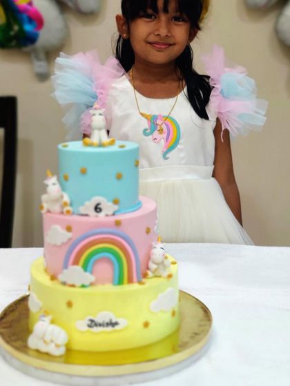A close-up of our daughter and her custom three-tier unicorn birthday cake. We loved bringing her vision to life with pastel colors and cute, handmade unicorns.
