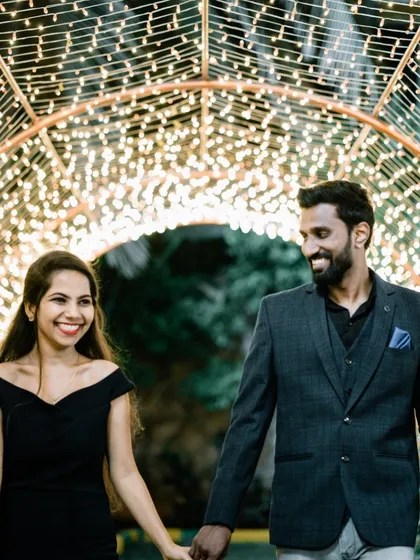 A couple walking hand-in-hand through a tunnel of lights, creating a magical and romantic atmosphere.