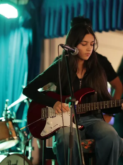 A student on electric guitar, performing with her band at our "Rhapsody in Radiance" event. This is what it's all about.
