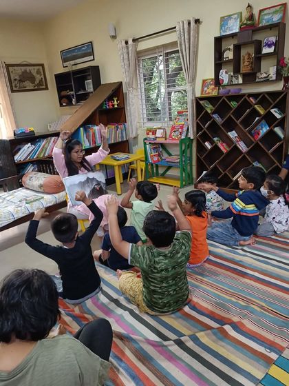 The children raise their hands, eager to participate in the story about the grouchy giant.
