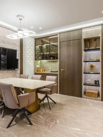 This perspective captures the full expanse of the dining and storage area. The design showcases our ability to integrate functional elements like storage and a TV unit into a cohesive and glamorous aesthetic.