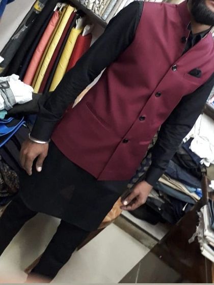 A client in my shop wearing a custom-fit maroon Nehru jacket over a black kurta set. This color combination is bold and sophisticated.